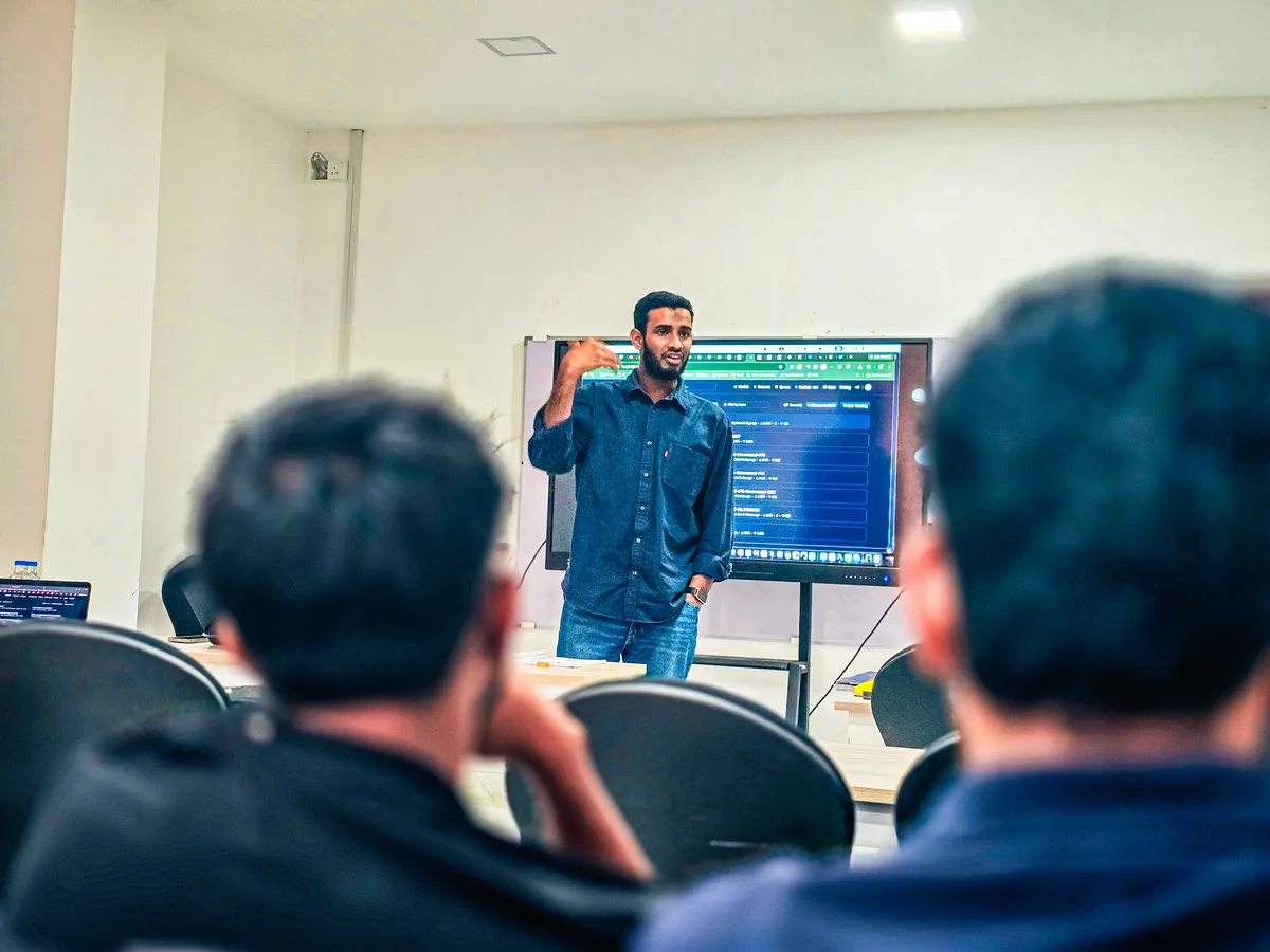 A Cocoon trainer explaining code on a large screen to a corporate team